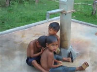 children bathing at a Lotus Outreach well